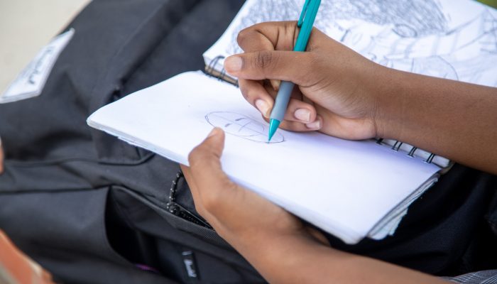 A person sketching in a notebook