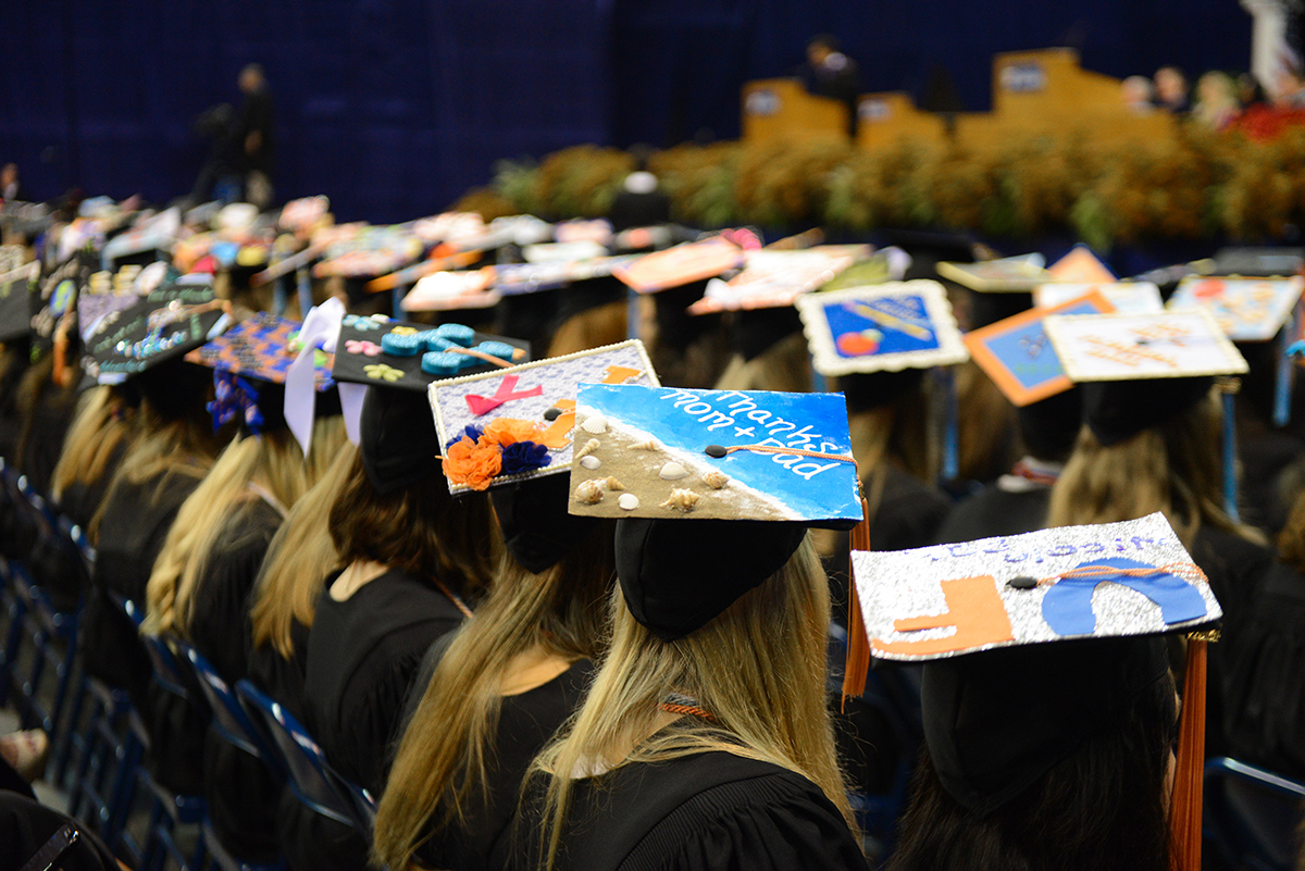 People sitting in a row wearing graduation caps