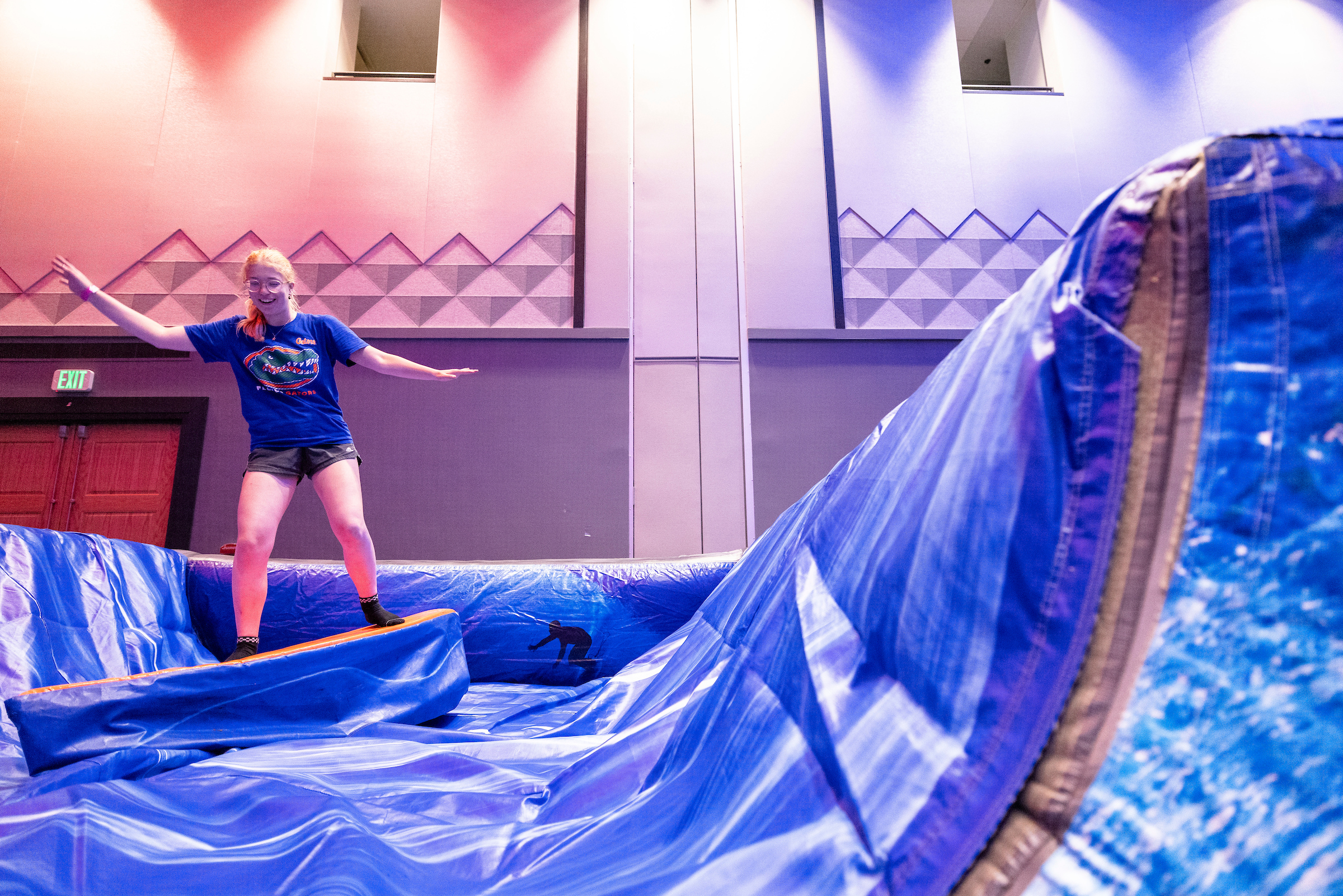 A student learns to surf on a mechanical surf board inside the reitz union's grand ballroom.