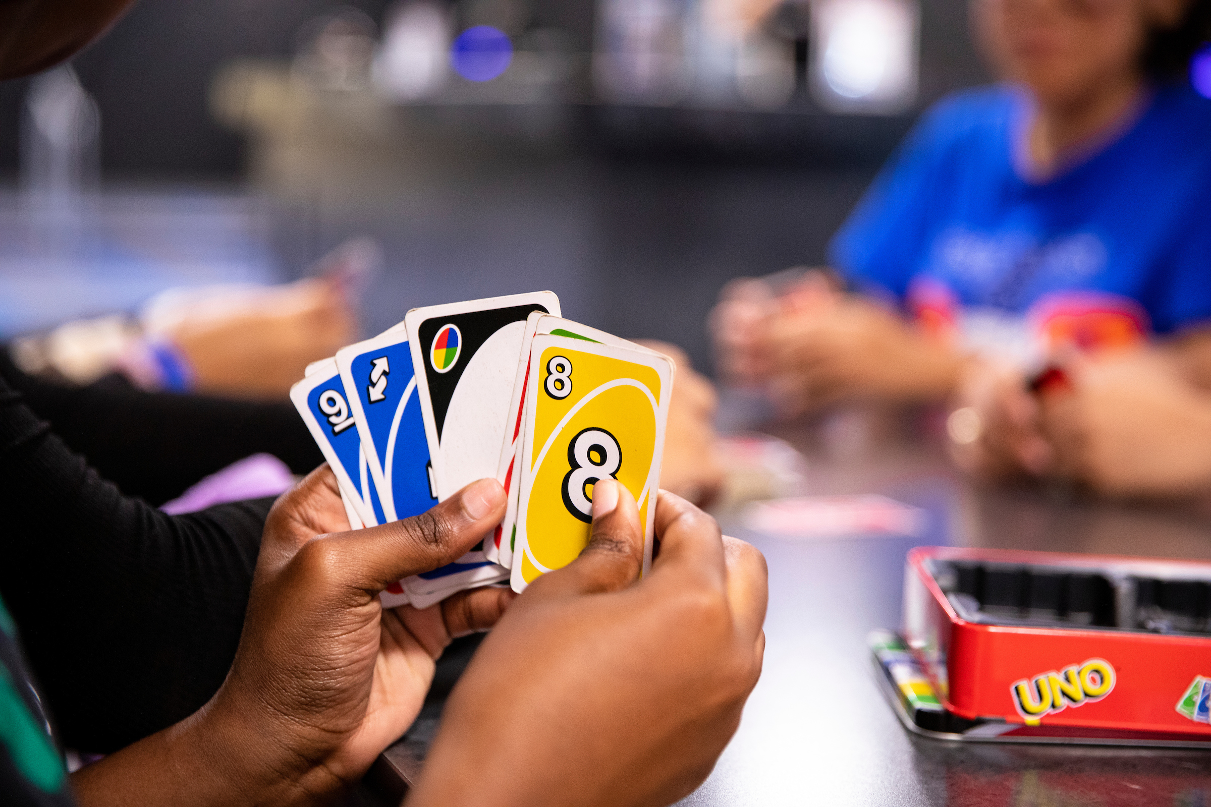 a Student shows their hand of Uno cards while playing the the Reitz Union Game Room.